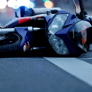 Einer der Motorradfahrer stürzt und kann von Schülern und Lehrern festgehalten werden (Symbolbild).