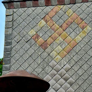 Das Hakenkreuz, gelb-orange auf grauen Schindeln, am höchsten Turm in Hönau-Lindorf