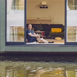 Aufnahme des Hausboot-Besitzers Daniel Wickersheim, wie er an seinbem geöffneten Wohnzimmerfenster sitzt.