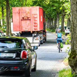 Zwei Pkw und ein Lkw auf der Ebertallee, rechts daneben eine Radfahrerin