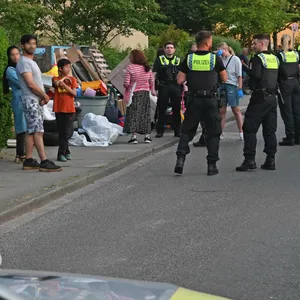 Polizei und mehrere Anwohner stehen am Gottschalkring vor Sperrmüllhaufen