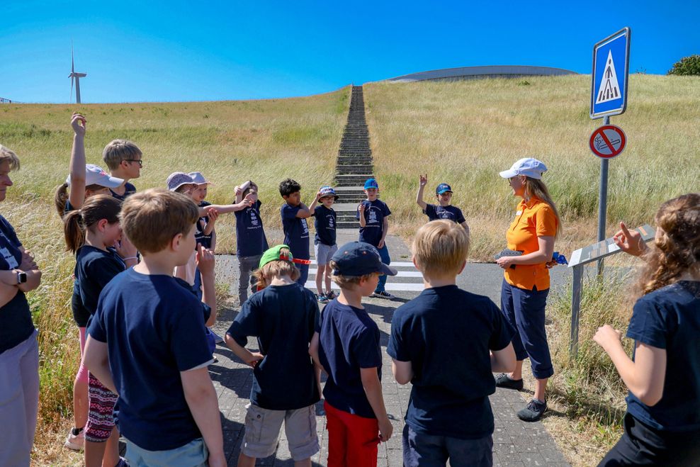 Die Schüler:innen der Fridtjof-Nansen-Schule stehe in einem Kreis und bekommen eine Einführung zum Thema Plastikmüll.