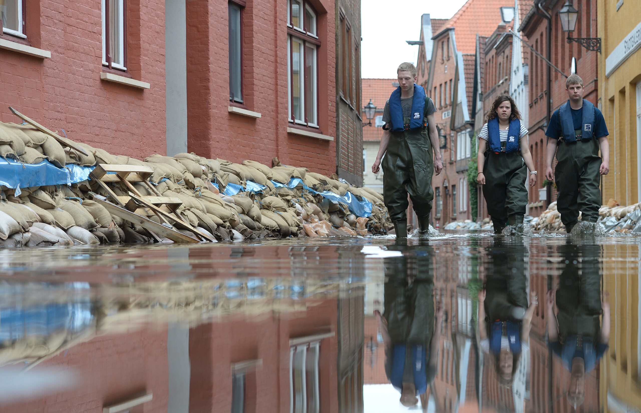 2013: Helfer gehen durch eine überflutete Straße in Lauenburg.