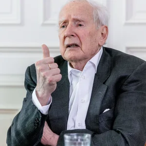 Klaus von Dohnanyi sitzt vor einer weißen Tür.