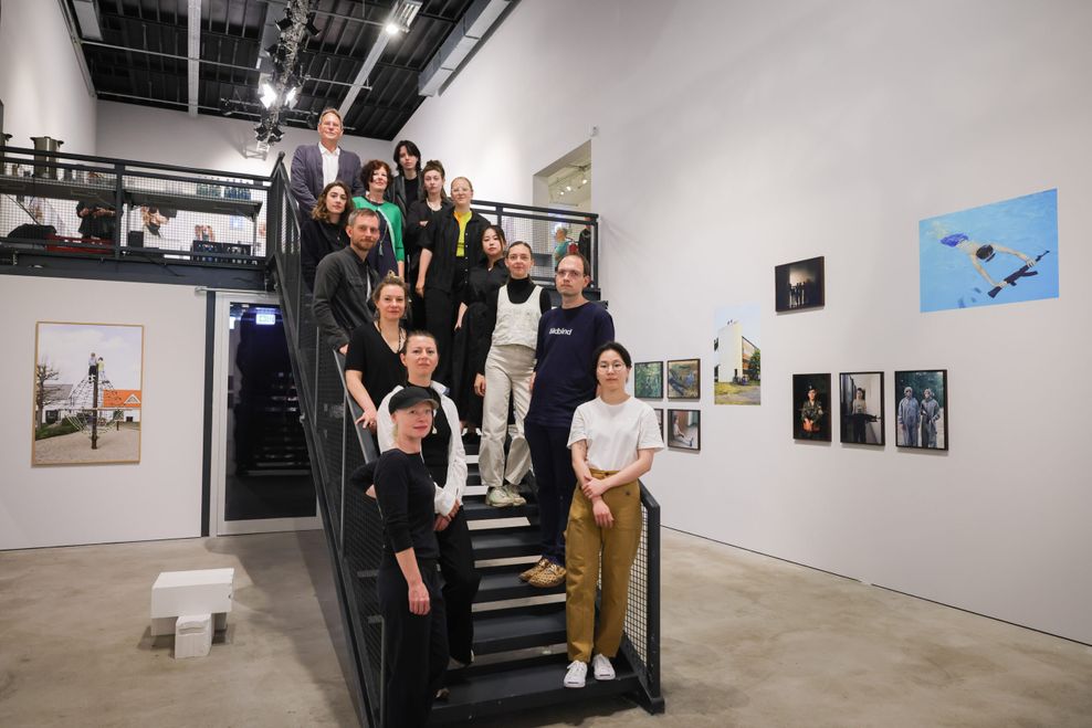 Menschen stehen in einem Raum auf einer Treppe