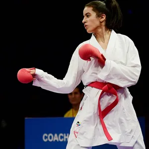 Reem Khamis im weißen Kampfanzug und roten Boxhandschuhen.