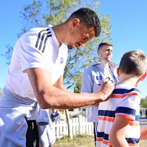 Robert Glatzel signiert ein Shirt eines jungen HSV-Fans.