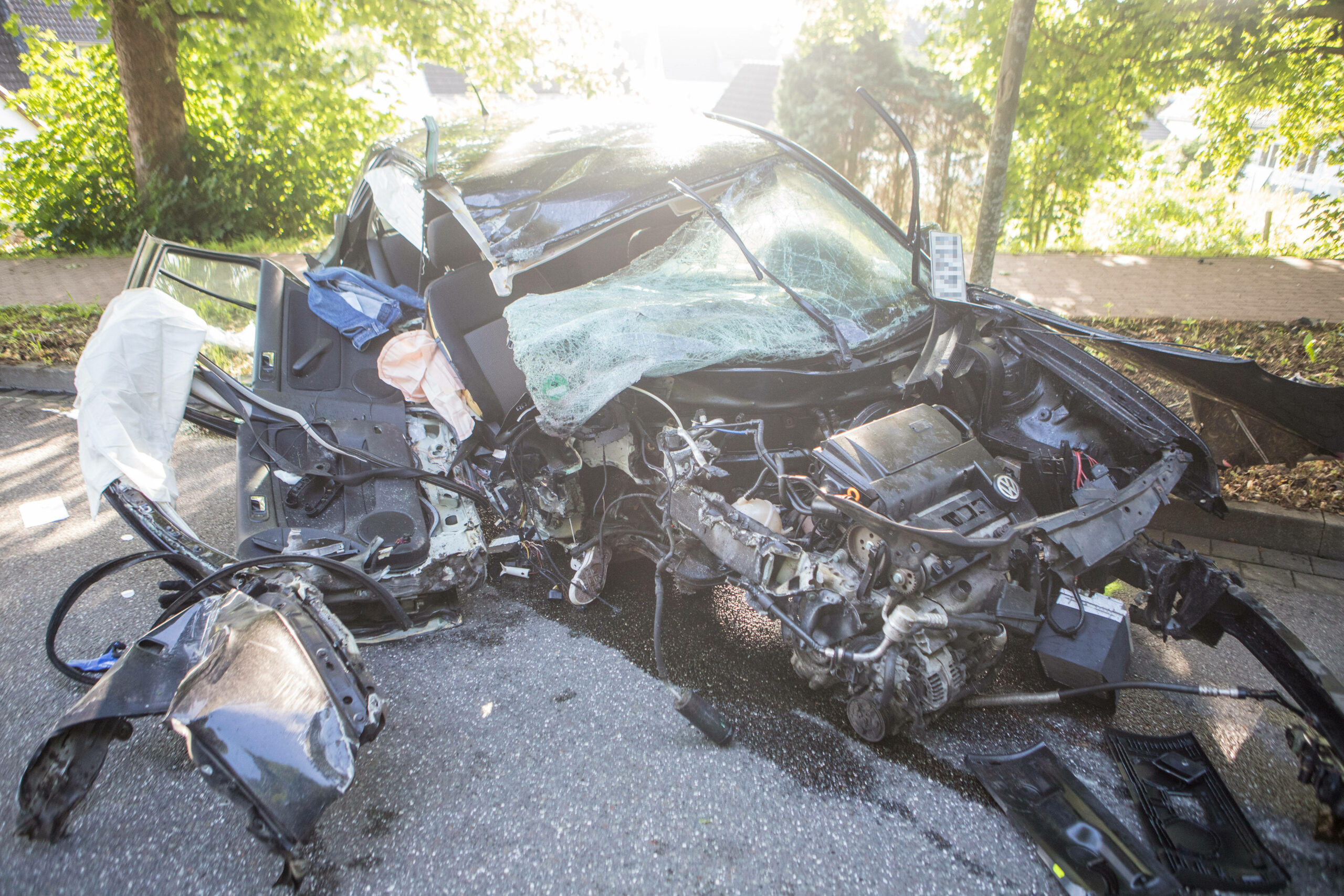 Der völlig zerstörte VW Golf: Ein Vorderrad ist abgerissen, der Motorblock liegt auf der Straße.