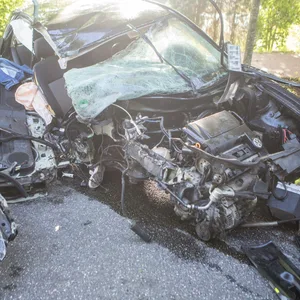 Der völlig zerstörte VW Golf: Ein Vorderrad ist abgerissen, der Motorblock liegt auf der Straße.