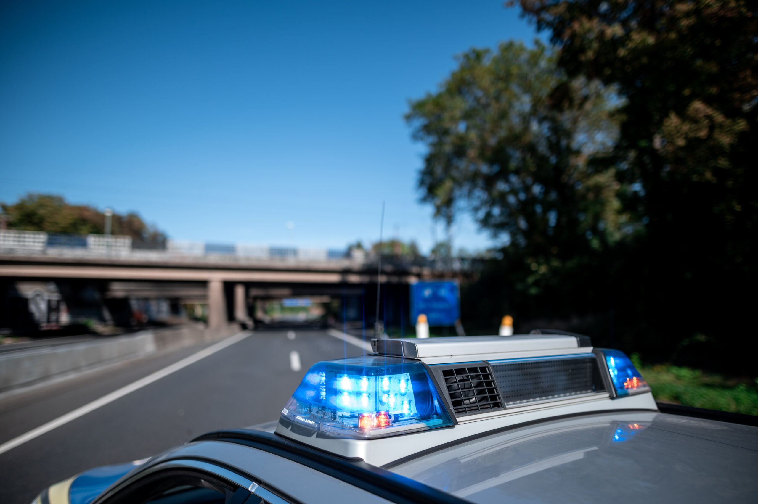 Polizeiblaulicht mit einer Brücke im Hintergrund