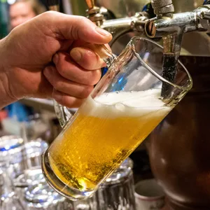 Ein Bier wird in einer Gaststätte gezapft.