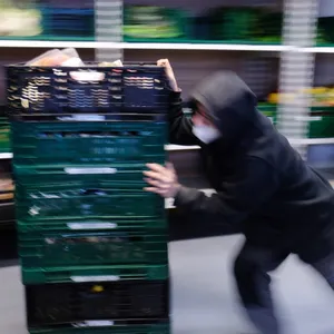 Ein Mann schiebt Lebensmittelkisten