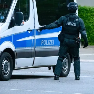 Ein Polizist der USE-Einheit an seinem Einsatzfahrzeug.