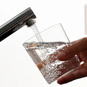 Wasserhahn und Glas