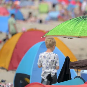 Strandgäste sind bei sommerlichem am Badestrand von Schillig.