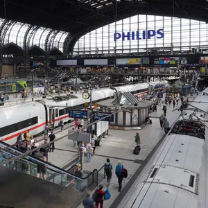 Gleise des Hamburger Hauptbahnhofs mit Zügen und dem großen Glasfenster im Hintergrund