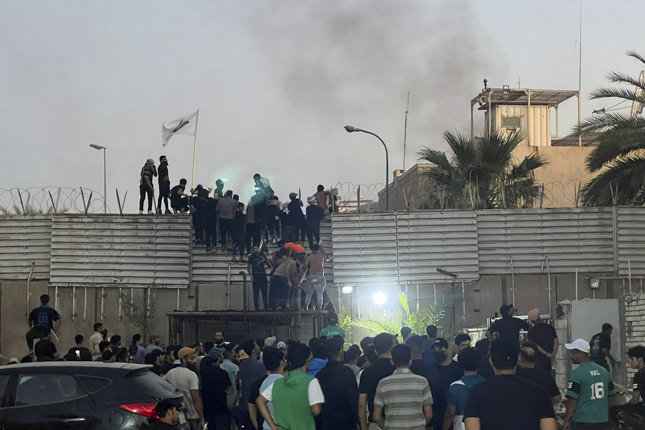 Demonstranten erklimmen eine Mauer an der schwedischen Botschaft im Irak.