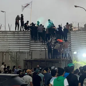 Demonstranten erklimmen eine Mauer an der schwedischen Botschaft im Irak.