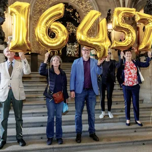 Mitglieder der Volksinitiative «Schluss mit Gendersprache in Verwaltung und Bildung» halten im Rathaus Ballons mit der Zahl 16457 in die Höhe. So viele Unterschriften hat die Volksinitiative kurz zuvor an den Hamburger Senat übergeben.