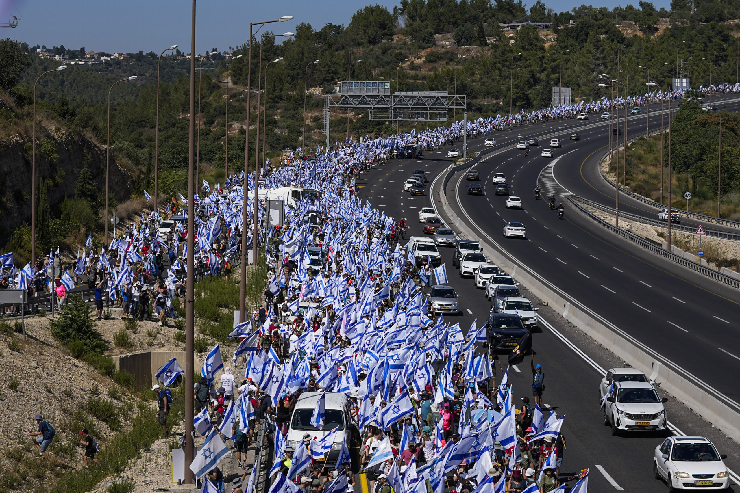 Israel-Fahnen werden von Demonstrierenden über die Autobahn getragen.