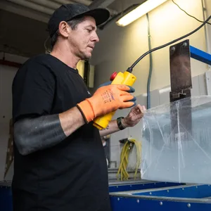 Sezgin Albayrak hebt in seiner Berliner Eisfabrik mit Hilfe eines Krans einen Eisblock aus der Form.