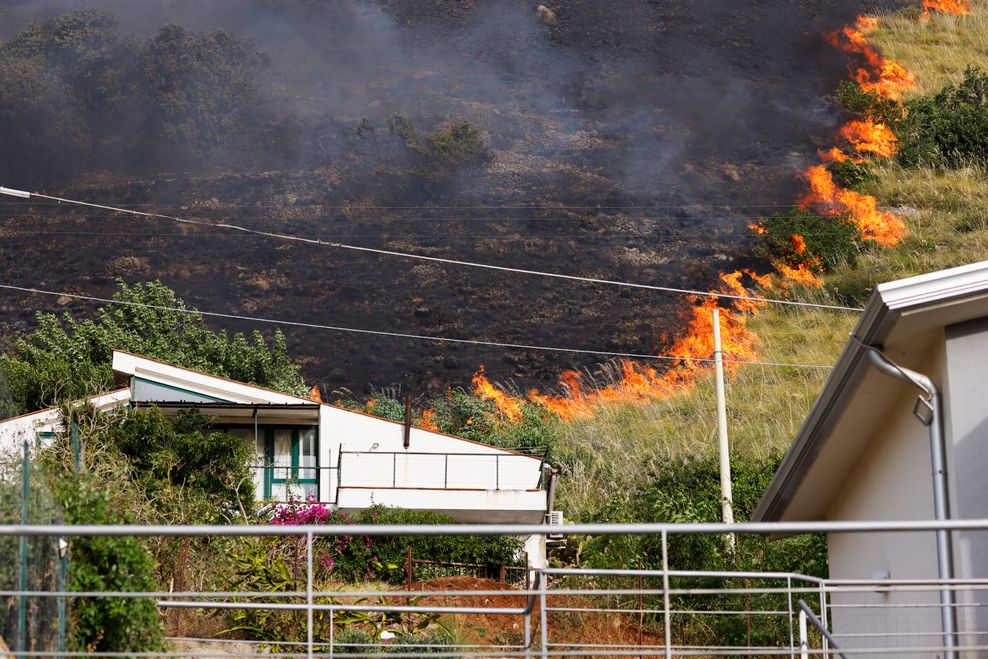 Ein Feuer breitet sich auf einer Fläche hinter einem Wohnhaus in der Nähe von Palermo aus.