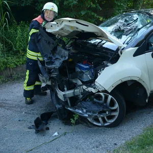 Ein Feuerwehrmann begutachtet das Unfallfahrzeug