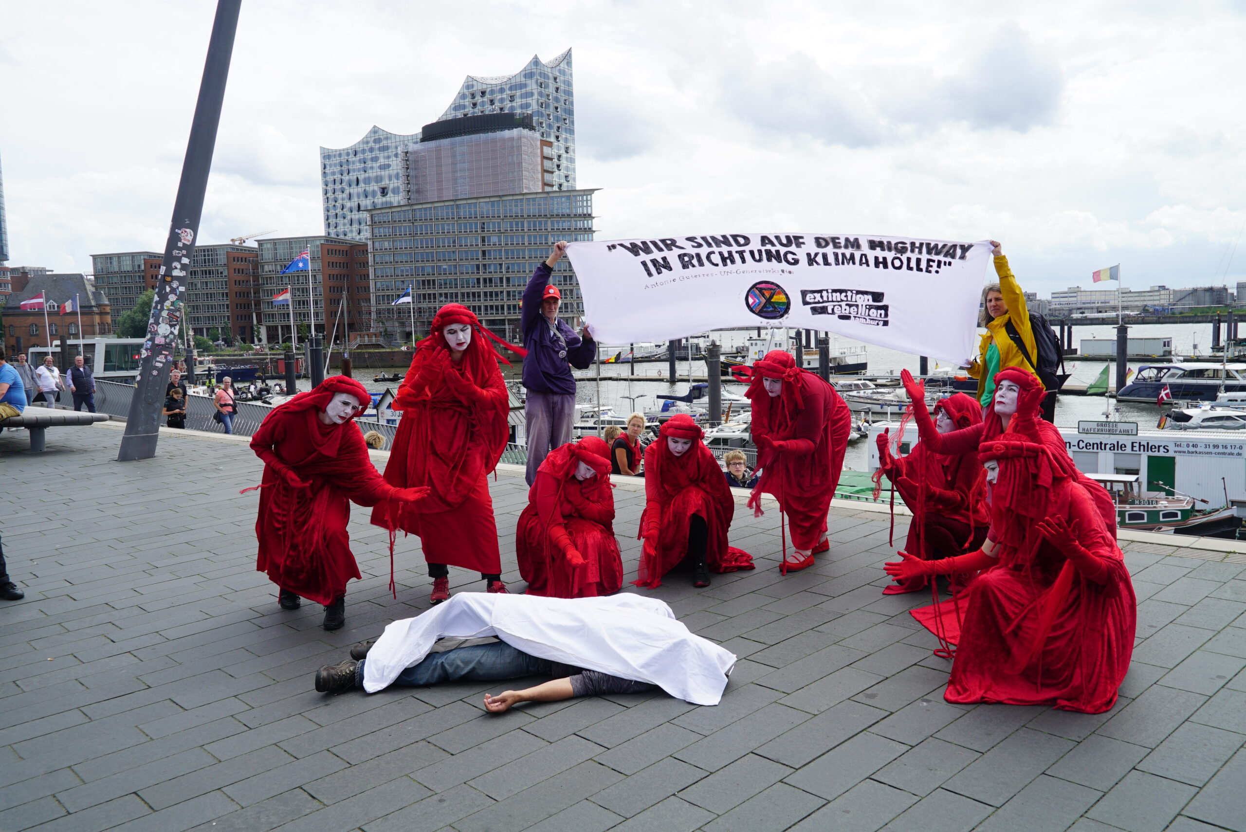 Die Aktivisten trugen rote Gewänder und legten Leichentücher über einen Mann und ein Baby.