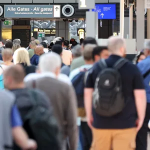 Reisende stehen in einer langen Schlange vor der Sicherheitskontrolle am Hamburger Flughafen an.