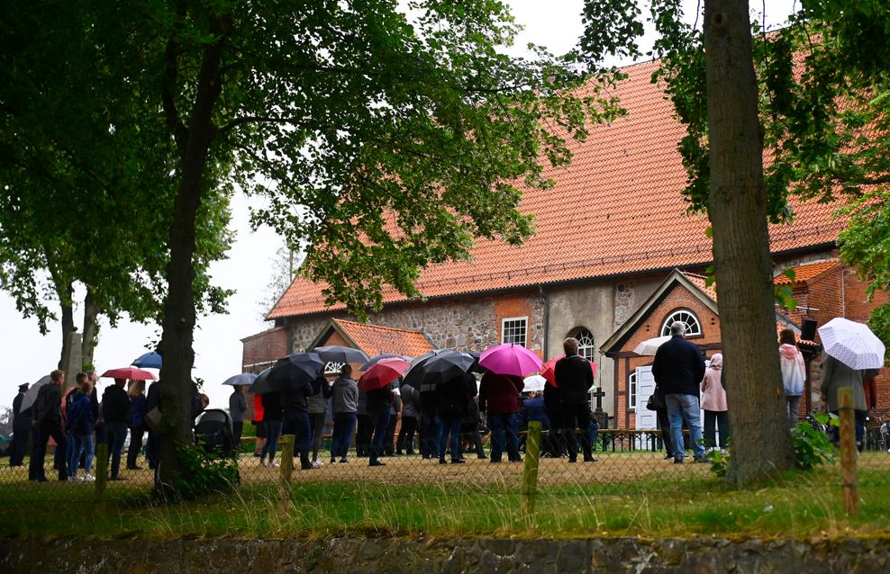 Trauernde vor der Kirche