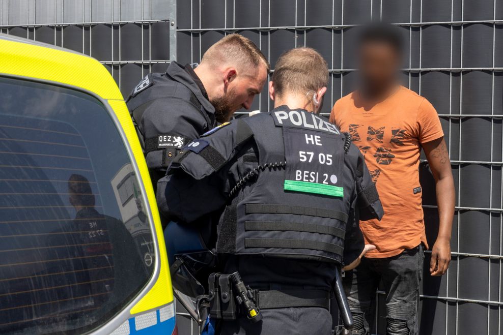 Polizisten kontrollieren am Rande des Eritrea-Festivals in Gießen einen Mann.
