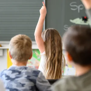 Aufnahme einer Schulklasse, in der sich die Schüler im Unterricht melden.