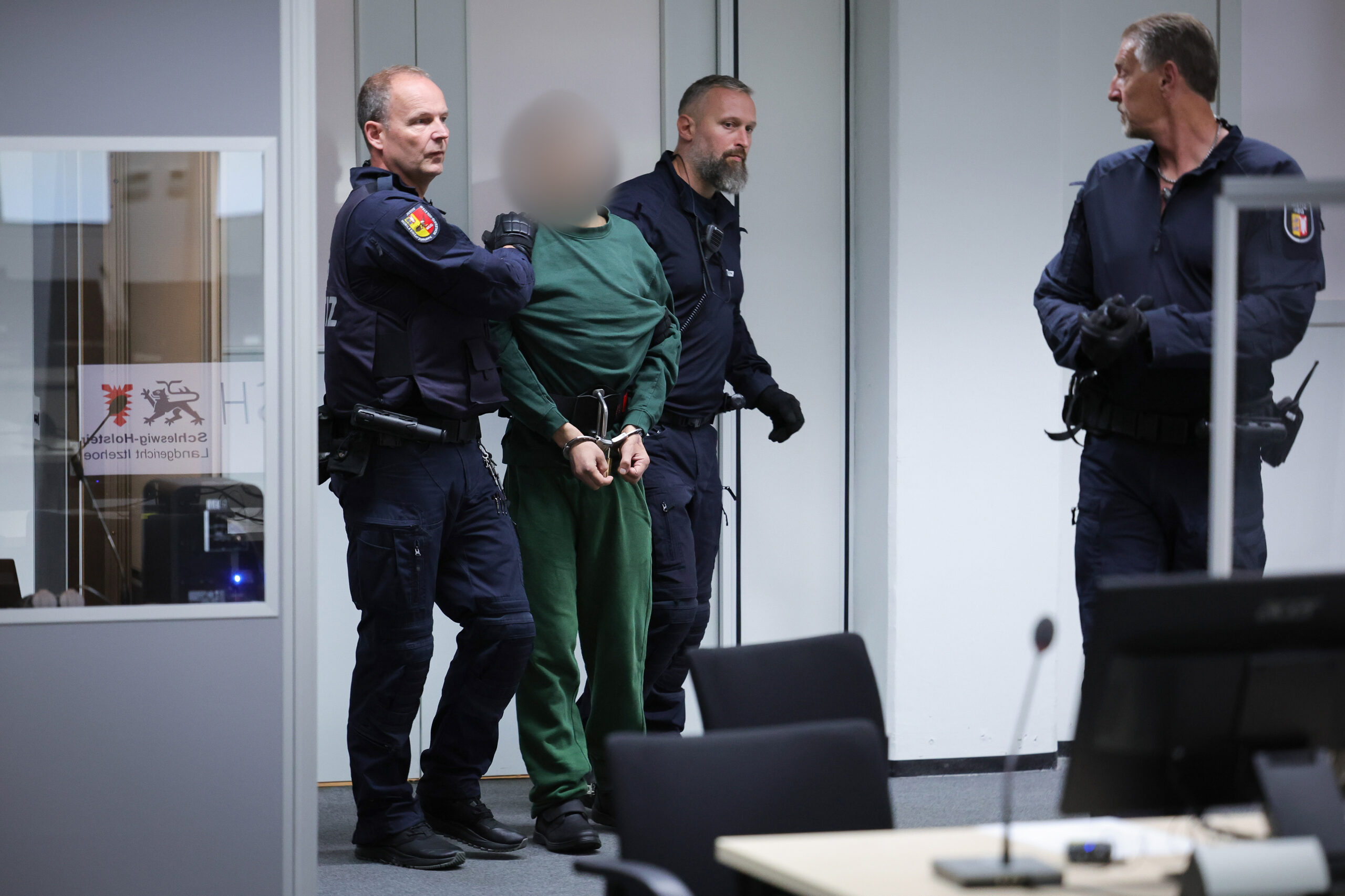 Justizbeamte bringen den Angeklagten Ibrahim A. in den Gerichtssaal.