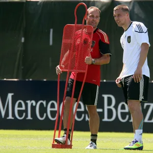 Lukas Podolski und Hansi Flick zusammen auf dem Trainingsplatz im Jahr 2011.
