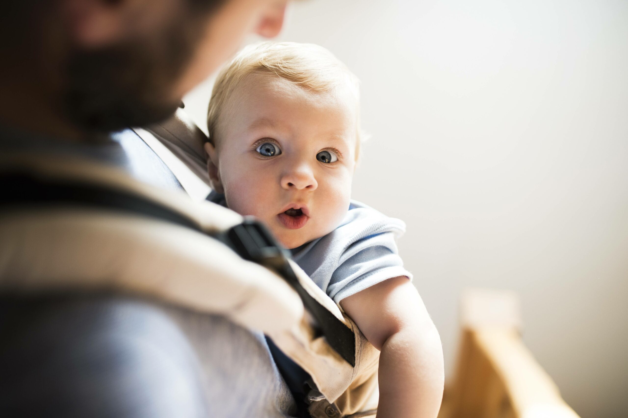 Ein Baby in einer Trage auf der Brust seines Vaters