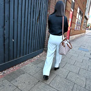 Eine Frau von hinten/seitlich, die alleine durch die Straßen läuft.