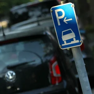 Parkende Autos, im Vordergrund ein Park-Hinweisschild (Symbolbild).