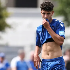 Daniel Elfadli zieht sich sein Trikot vors Gesicht.
