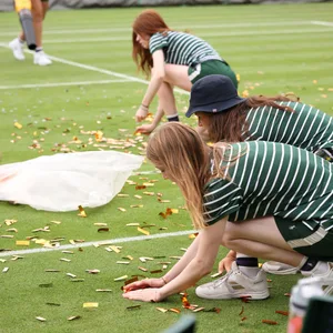 Helferin beim Wimbledon-Tunier sammeln Konfetti auf.