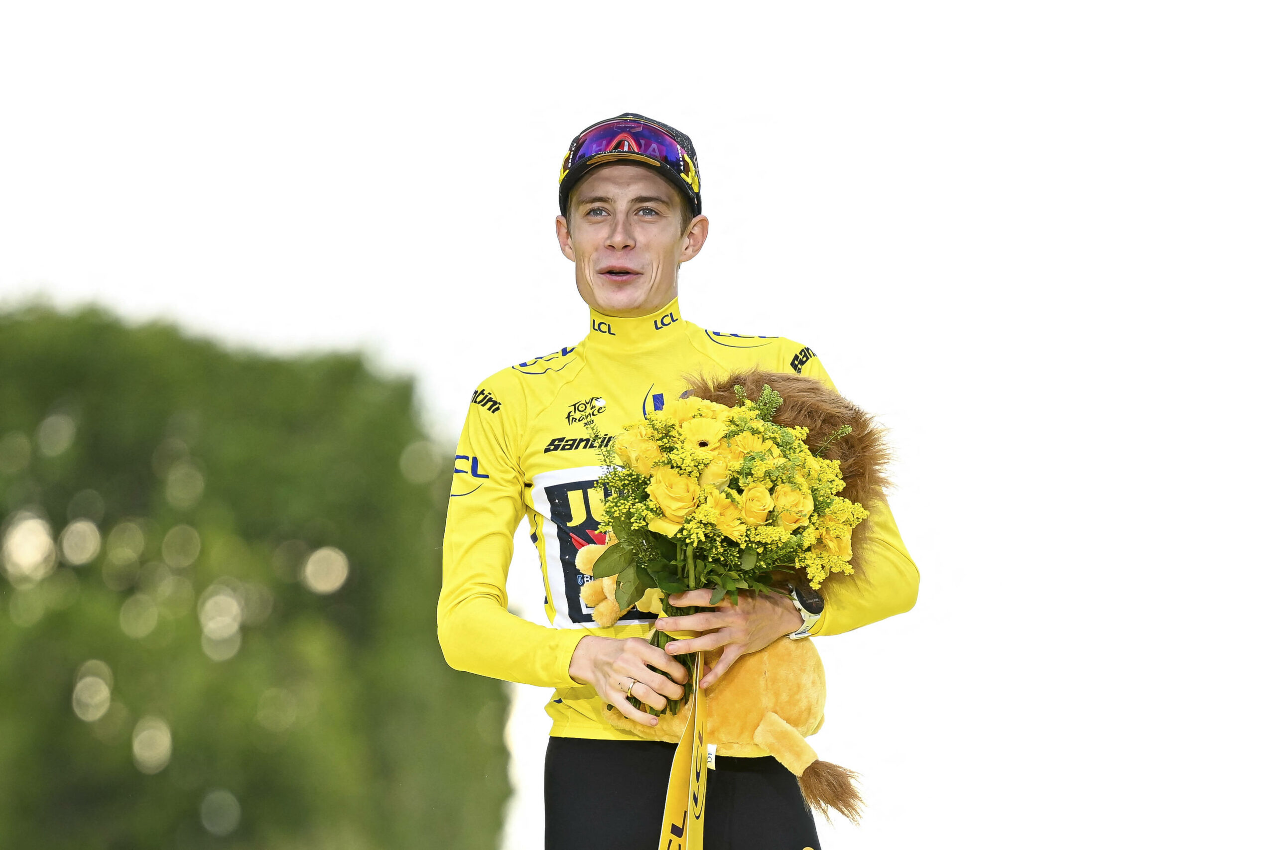 Jonas Vingegaard mit Blumen in der Hand und im gelben Trikot.
