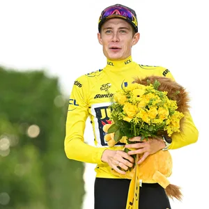Jonas Vingegaard mit Blumen in der Hand und im gelben Trikot.