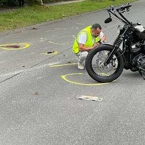 Die Unfallstelle an der Hermann-Balk-Straße. Auf der Straße sind Trümmerteile und eine Blutspur markiert.