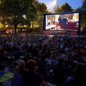 Openair-Kino bei Nacht, hinten Leinwand, davor das Publikum