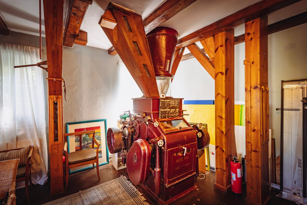 Restaurierte Holzbalken neben einem „Doppelten Walzenstuhl“ der alten Mühle