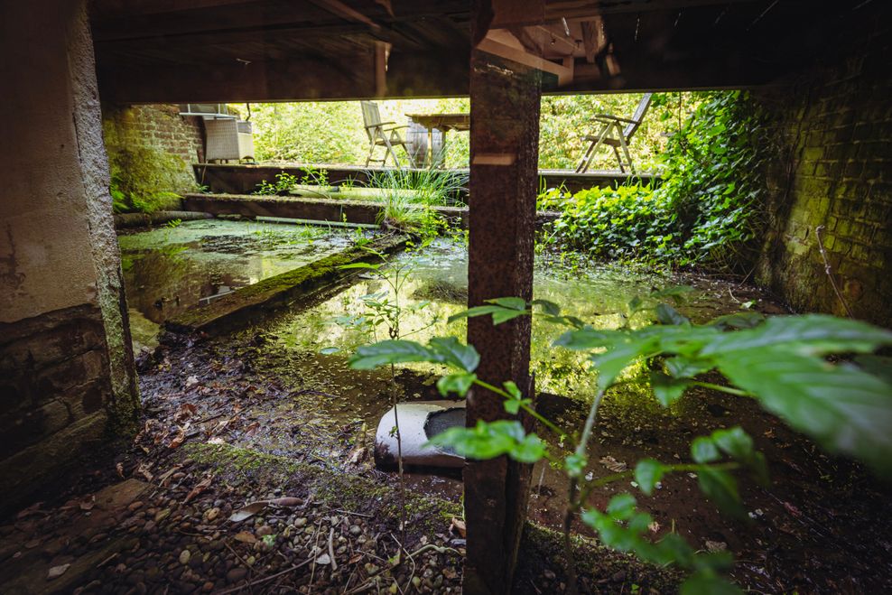 Blick vom Untergeschoss auf einen Wasserlauf, der früher einmal das Mühlenwehr speiste