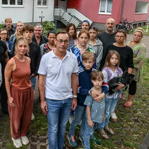 Betroffenene Mieter stehen für ein Gruppenfoto vor einem der Wohnhäuser der „PEG“-Hamburg.