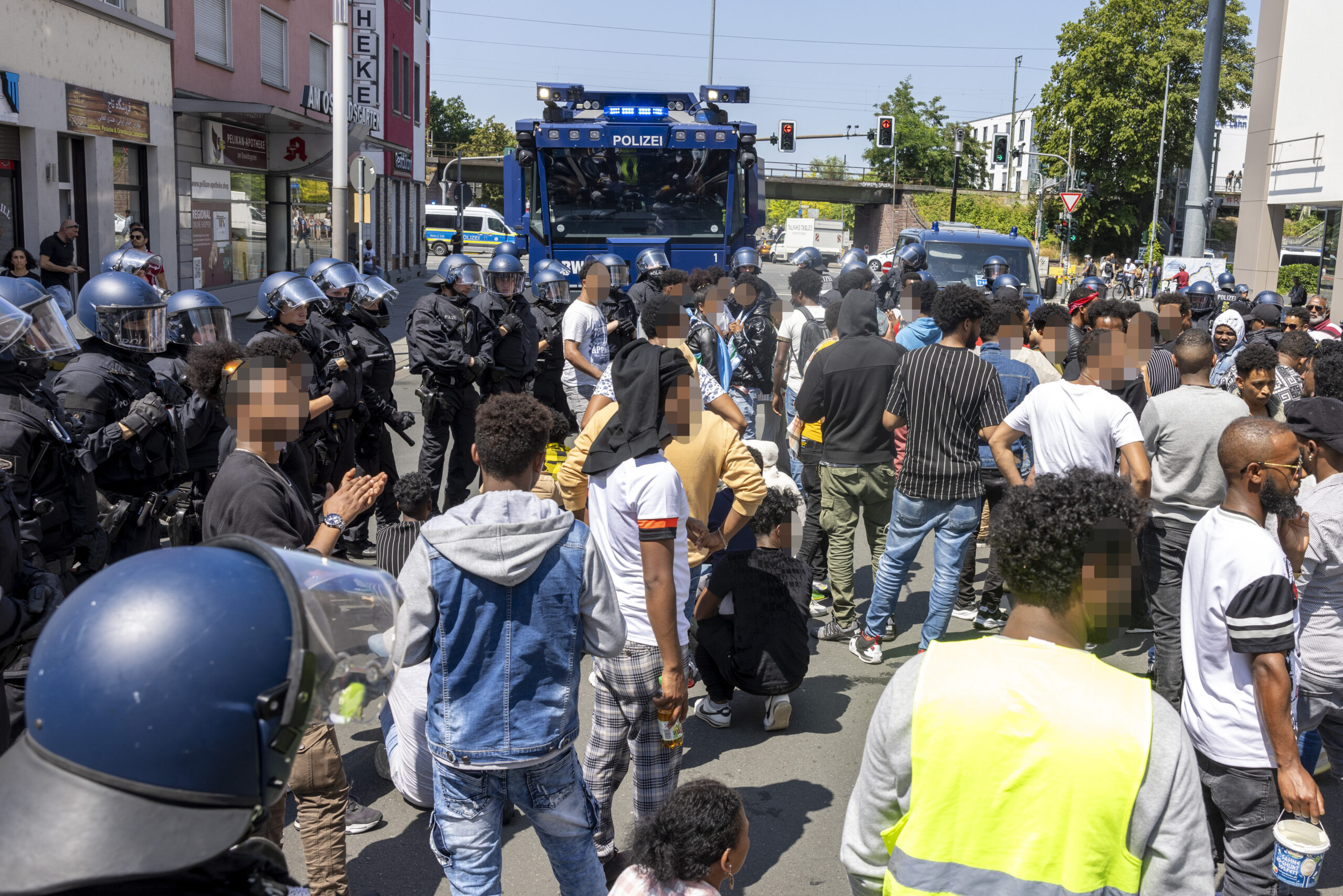 Polizisten haben am Rande des Eritrea-Festivals in Gießen eine Gruppe von Menschen umringt. Im Hintergrund steht ein Wasserwerfer bereit.