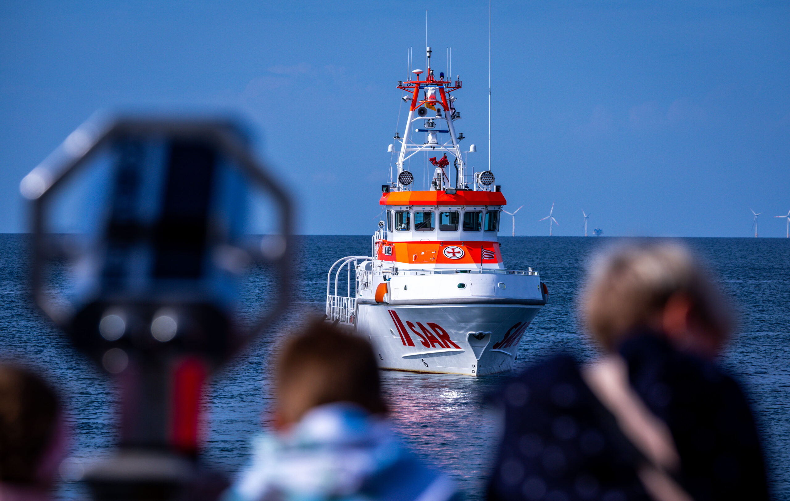 Der 28 Meter lange und fast 4.000 PS starke Seenotrettungskreuzer "Nis Randers" wird bei einer Einsatzübung auf der Ostsee vor der Halbinsel Fischland-Darf-Zingst von Touristen auf der Seebrücke beobachtet.