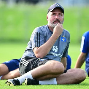 Tim Walter auf dem Trainingsplatz sitzend