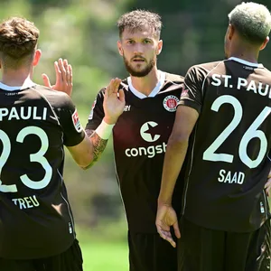 Philipp Treu und Marcel Hartel freuen sich zusammen mit Torschütze Elias Saad.